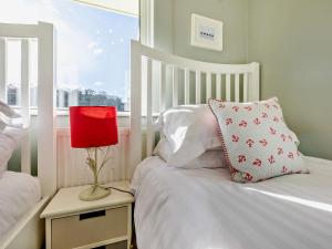 a bedroom with a bed with a red lamp and a window at 3 Bed in Combe Martin 41580 in Combe Martin