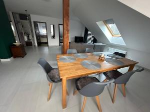a wooden table and chairs in a room at Apartament Oksford 3 in Okszów