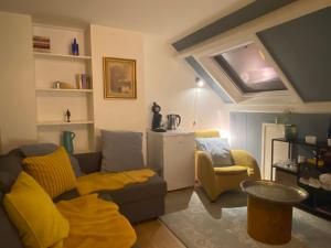 - un salon avec un canapé et une couverture jaune dans l'établissement Bed and breakfast Carma Arnhem, à Arnhem