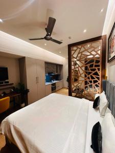 una camera da letto con un grande letto bianco e un ventilatore a soffitto di Yourhomely Studio a Ghaziabad
