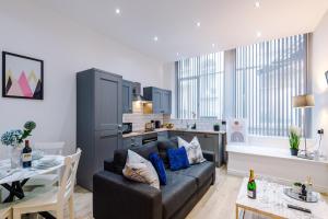 a living room with a couch and a kitchen at Modern 2-bedroom Apt In The Heart Of City Centre in Liverpool