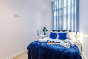 um quarto com uma cama azul com toalhas em Modern 2-bedroom Apt In The Heart Of City Centre em Liverpool