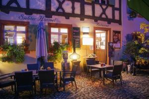 a restaurant with tables and chairs and a umbrella at Gästehaus Siebter Himmel in Burkheim