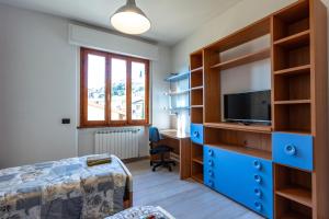 um quarto com uma cama, uma secretária e uma televisão em Accogliente casa a Pontassieve em Pontassieve