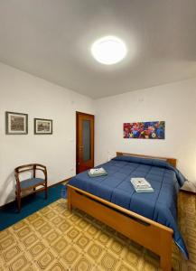 a bedroom with a blue bed and a chair at Matchpoint Apartment in Sanremo