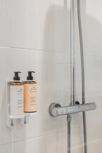 two bottles ofodorizers on a shelf in a bathroom at Hôtel Amaudo in Saint-François