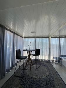 um quarto com uma mesa e duas cadeiras e janelas em Duplex Ametista em Gravatal