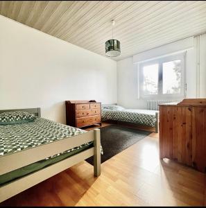 - une chambre avec un lit, une commode et une fenêtre dans l'établissement Appartement Illzach, 5 personnes, à Illzach