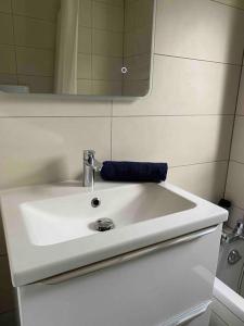 ein weißes Waschbecken im Bad mit Spiegel in der Unterkunft Appartement Illzach, 5 personnes in Illzach