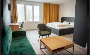 a bedroom with a bed and a couch and a table at Hotel Central Vis a Vis in Mainz