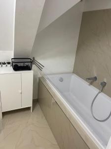 y baño con bañera blanca y lavamanos. en Apartmánový dům Jánský sen, en Janske Lazne