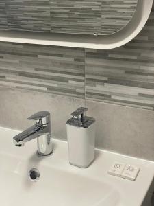 a bathroom sink with two faucets on top of it at Matchpoint Apartment in Sanremo