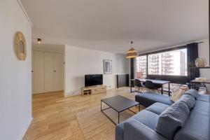 un soggiorno con un divano blu e un tavolo di Superb T4 close to the Stade de France (10 min) a Saint-Denis