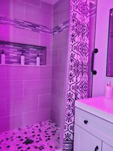 a pink bathroom with a shower with purple lighting at Modern Dream Rooms Suits - Private, parking, Wi-Fi, Netflix in Spring Hill