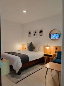 喬盧拉的住宿－CHOLULA SUITES，一间卧室配有一张大床和一张蓝色椅子