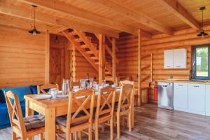 comedor con mesa y sillas en una cabaña en Zalesie - wyjątkowe domki nad jeziorem, en Zalesie