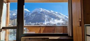 una ventana con vistas a una montaña en Studio 2-4 personnes, Le Portillo, proche hypercentre & vieux village, en Val dʼIsère