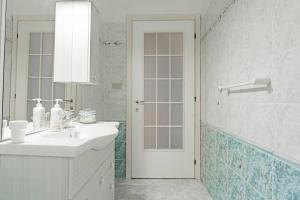 y baño blanco con lavabo y ducha. en R-House - Appartamento, en Collecorvino