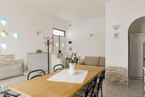 a dining room table with a vase of flowers on it at R-House - Appartamento in Collecorvino