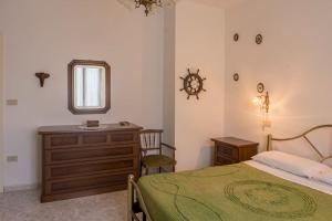 1 dormitorio con cama, tocador y espejo en R-House - Appartamento, en Collecorvino