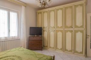 1 dormitorio con un gran armario verde y TV en R-House - Appartamento, en Collecorvino