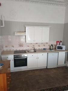 a kitchen with white cabinets and a sink at Eden Vale Ground Floor Sea View Apartment in Morecambe