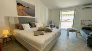 a bedroom with a large white bed and a couch at Apartments Villa Agatha in Sveti Filip i Jakov