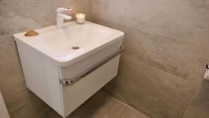 a white bathroom sink with a candle on it at Apartments Villa Agatha in Sveti Filip i Jakov +124 photos