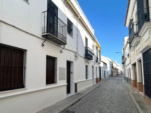 eine leere Straße in einer Gasse mit weißen Gebäuden in der Unterkunft Bonito apartamento en Utrera WIFI gratis in Utrera