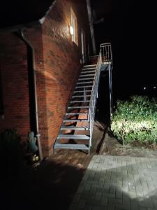 a staircase leading up to a brick building at night at Gästehaus Atrico Schleuse Wg 1 in Surwold