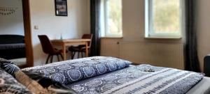 um quarto com uma cama, uma mesa e janelas em Suhl - Ihre erholsame Wohnung in Zentrumnähe em Suhl