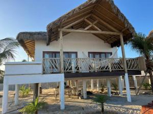 a house with a thatched roof on the beach at Jurema Branca Villa in Beberibe
