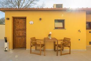 a yellow wall with a wooden table and chairs at La casetta di Grace in Sesto Fiorentino