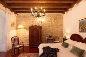 a bedroom with a bed and a chandelier at The Poets House Dubrovnik in Dubrovnik