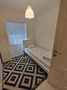 Habitación pequeña con cama y ventana en Balkan-Inn Apartments, en Belgrado