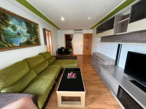 uma sala de estar com um sofá verde e uma mesa de centro em Cozy apartment for 6 people - Port Aventura em Vilaseca de Solcina