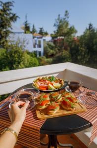 a woman sitting at a table with a tray of food at Grand House in Agios Nikolaos