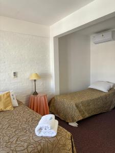 um quarto de hotel com duas camas e um candeeiro em Bagu Villa de Mar em Punta del Este