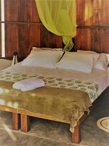 Una cama con dos almohadas encima. en Amazona Lodge, en Leticia