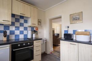 a kitchen with blue and white tiles on the wall at Castle Lodge Haughton Castle in Hexham