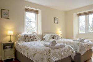 two beds in a bedroom with towels on them at Castle Lodge Haughton Castle in Hexham