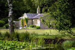 an old stone house in the middle of a field at Castle Lodge Haughton Castle in Hexham