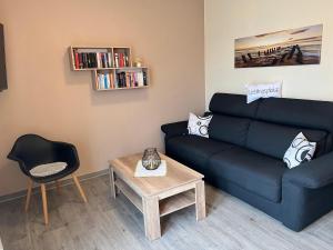 ein Wohnzimmer mit einem Sofa und einem Tisch in der Unterkunft Ferienwohnung Nordsee in Krummhörn