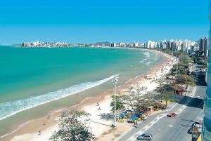 vistas a una playa con gente y al océano en Espaço Hale Kai en Guarapari