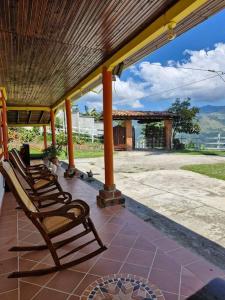 a group of chairs sitting on a porch at Finca los Juanes in Jardin