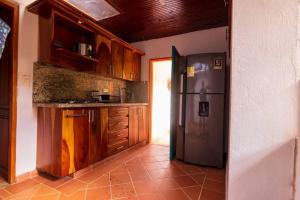 eine Küche mit einem Kühlschrank aus Edelstahl und Holzschränken in der Unterkunft Finca los Juanes in Jardin