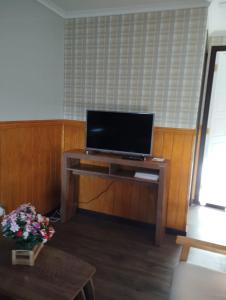 Una sala de estar con un televisor sobre una mesa de madera. en Cabañas Marina del Sur 1, en Puerto Natales