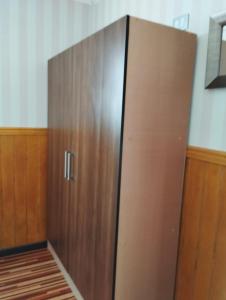 a large wooden cabinet in the corner of a room at Cabañas Marina del Sur 1 in Puerto Natales
