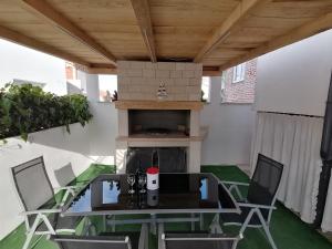 una mesa y sillas en un patio con chimenea en Apartments Paola en Trogir
