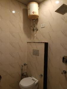 Hotel Tej Plaza Near IGI Airport في نيودلهي: حمام مع مرحاض وخزان مياه